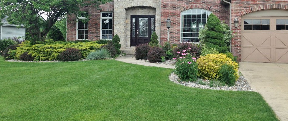 Rock landscape bed with mulch and red shrubs in Elkhart, IN.