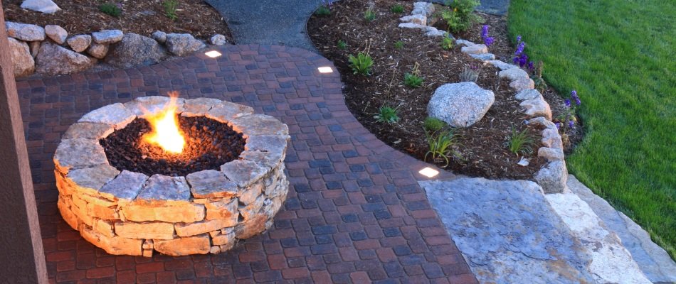 Custom stone fire pit on red brick patio in Elkhart, IN.