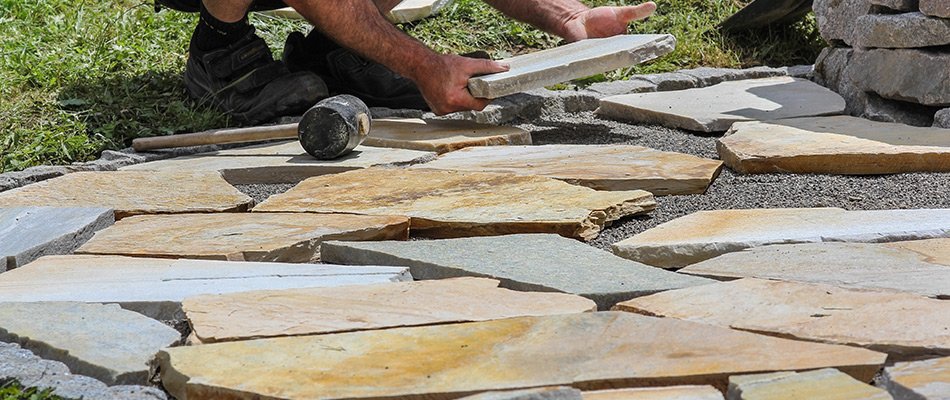 Landscaping professional laying flagstone near Jimtown, IN.