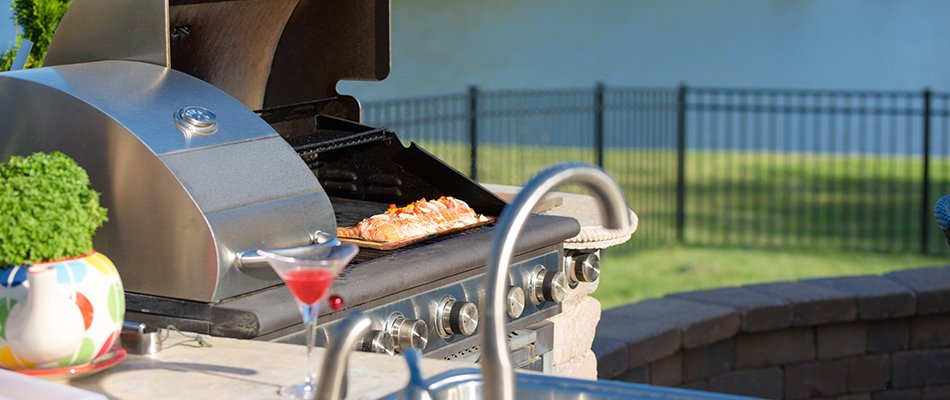 Modern outdoor kitchen with granite counter tops and silver grill near South Bend, IN.