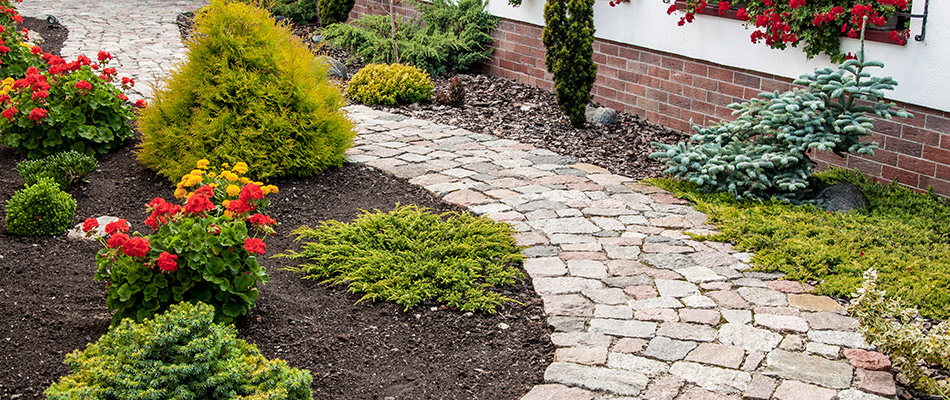 A stone walkway aligned with landscape beds installed by a home in Elkhart, IN.